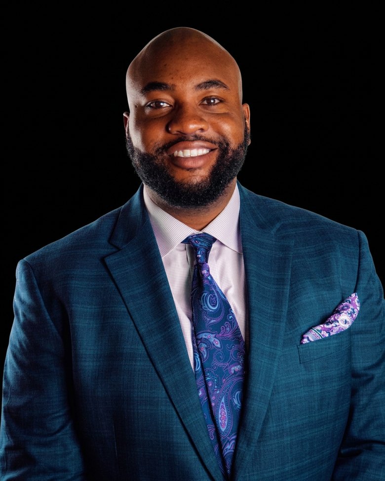 Chris Harper, BlackSalt Group partner, smiling in a teal suit with a patterned tie.